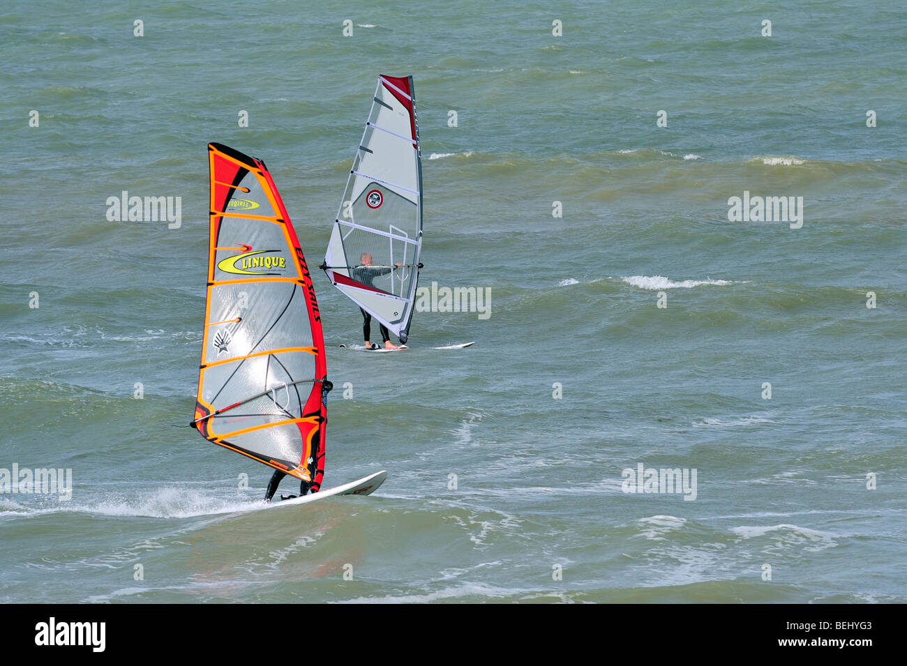 Two windsurfers sailing in the surf at sea Stock Photo