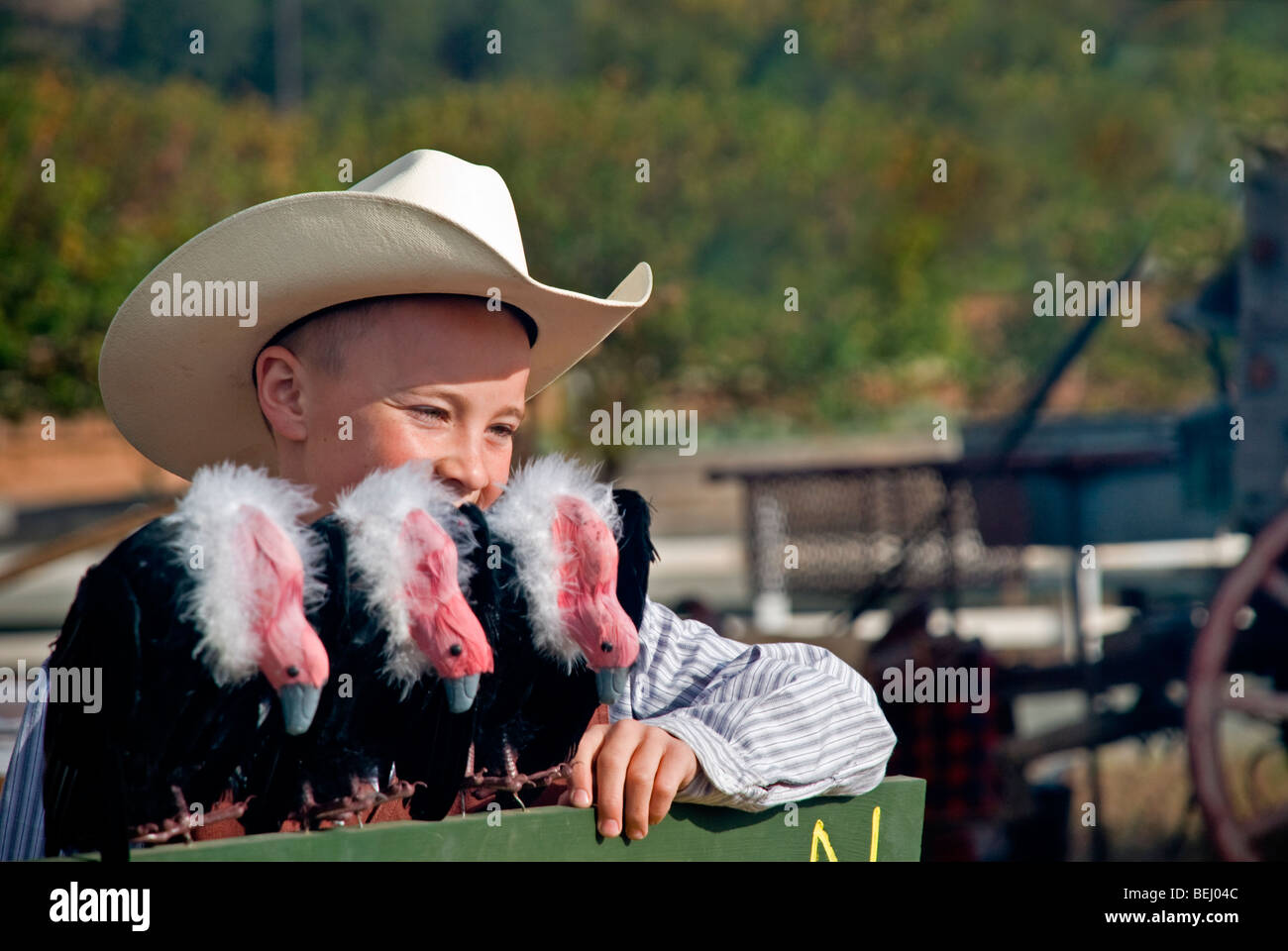 A happy young cowboy poses with three buzzards at the annual Cowboy Symposium in Ruidoso Downs, New Mexico. Stock Photo