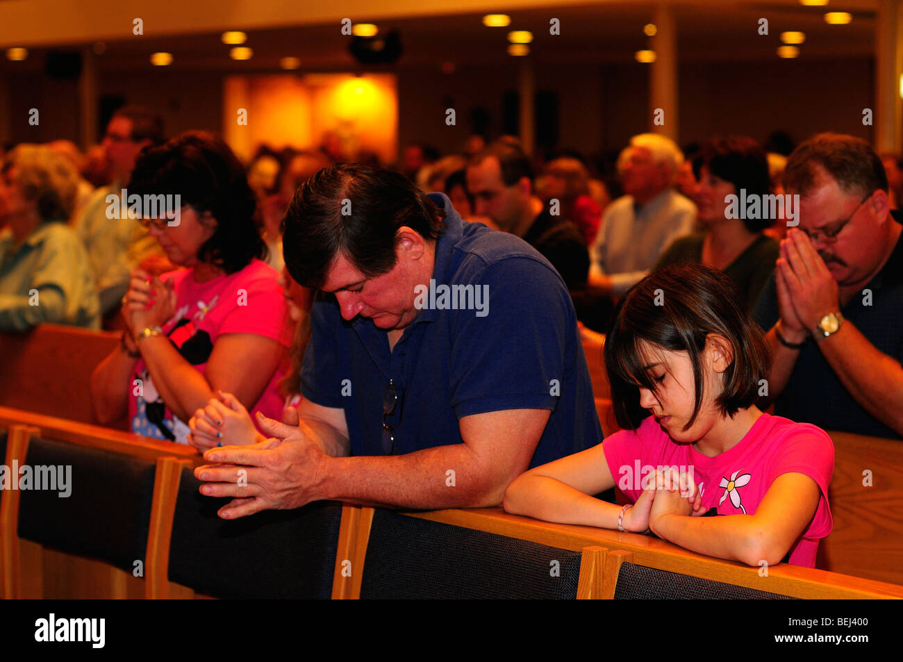 A family prays together at a Catholic church. Stock Photo