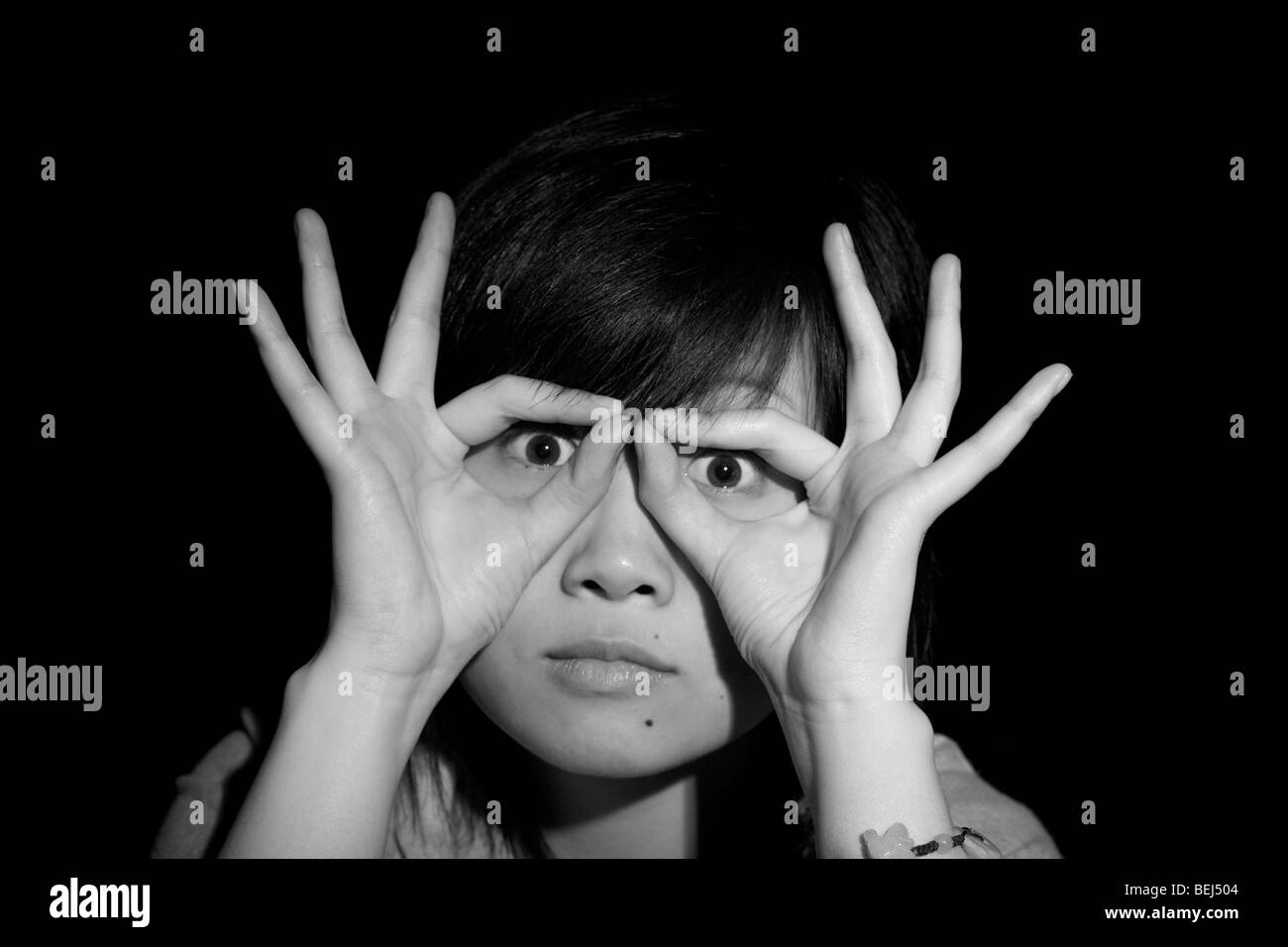 Young Asian woman making a pair of spectacles with her hands. Stock Photo