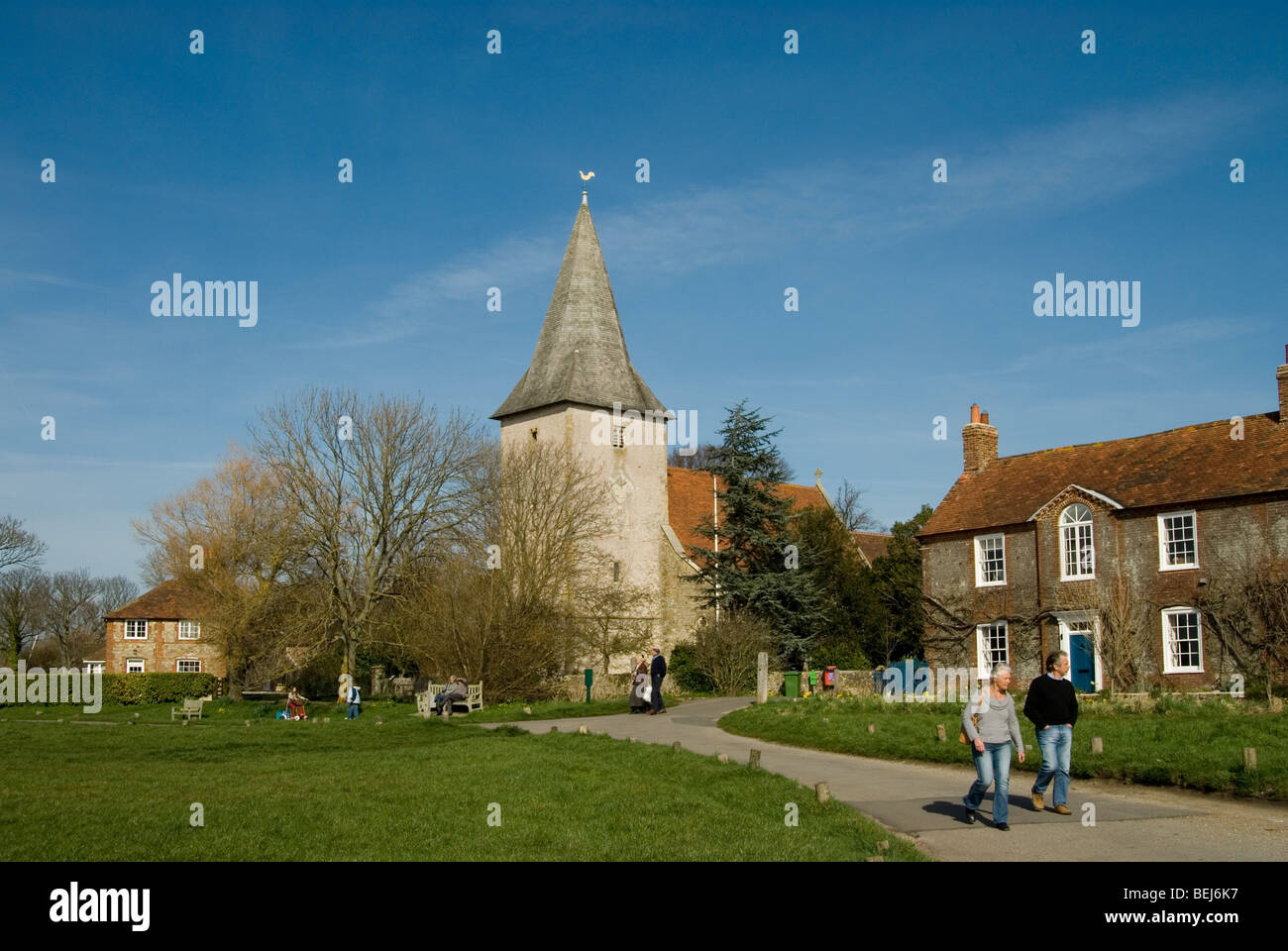Bosham church on a sunny day with people walking and sitting Stock Photo
