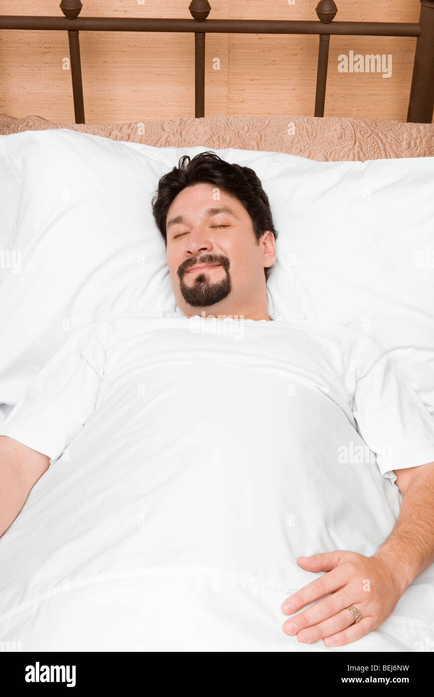 Mid adult man sleeping on the bed Stock Photo - Alamy
