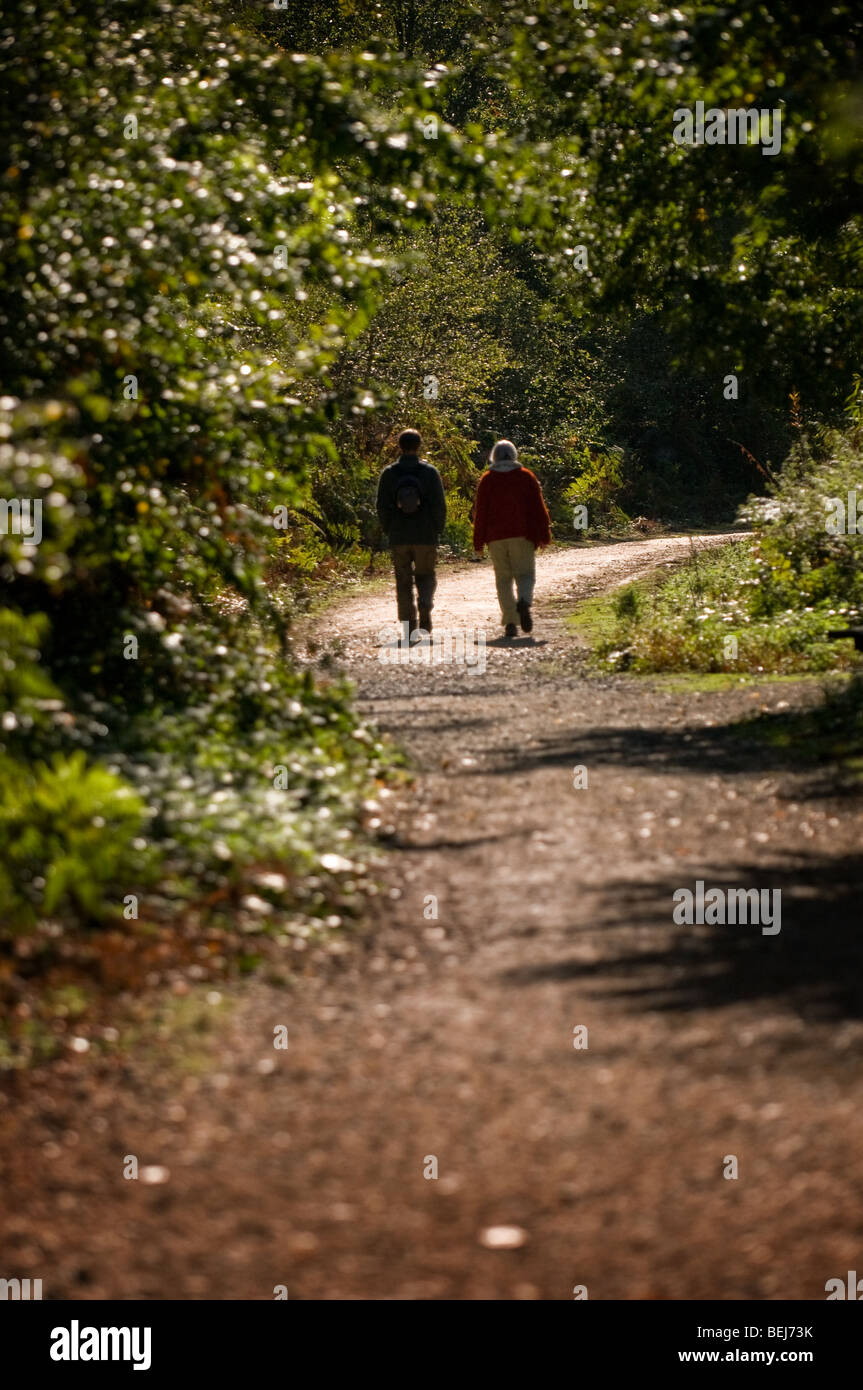 A man and a woman walking along a path in Thorndon Park in Essex. Photo ...