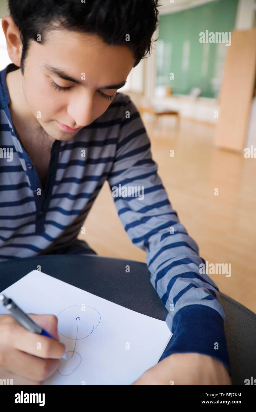 Young man drawing on a sheet of paper Stock Photo - Alamy
