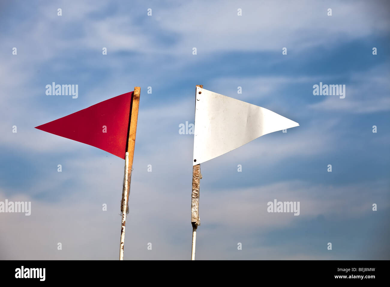 Red and white flag against blue sky Stock Photo