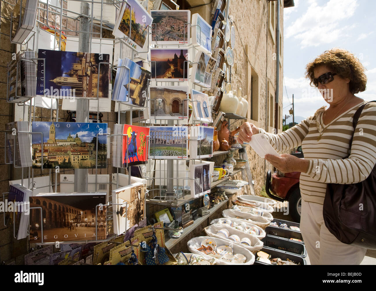 Woman tourist looking at postcard outside souvenir shop, Segovia, Spain Stock Photo
