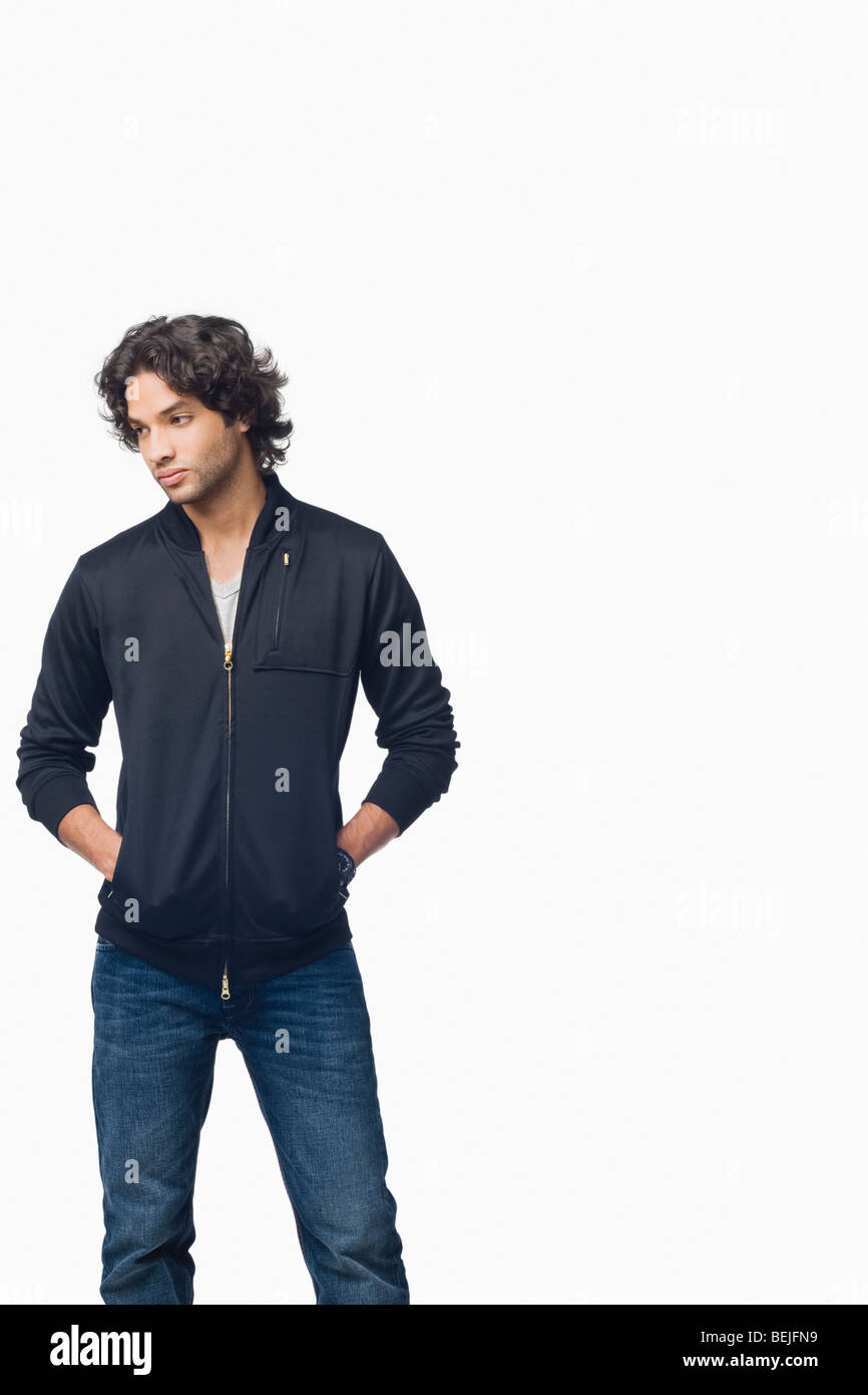 Young man standing with his hands in his pockets Stock Photo - Alamy