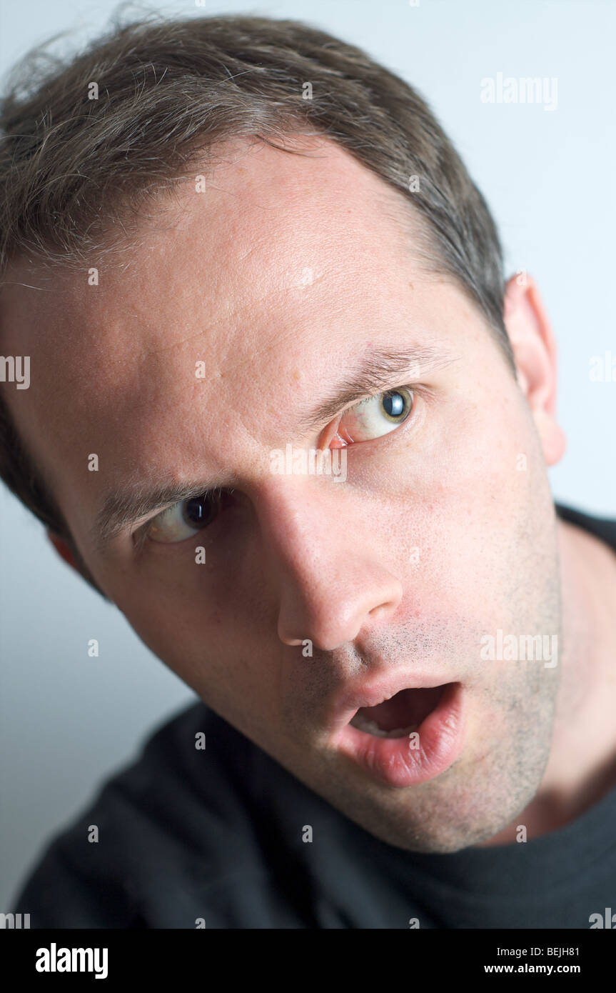 Curious Man looking around the corner Stock Photo