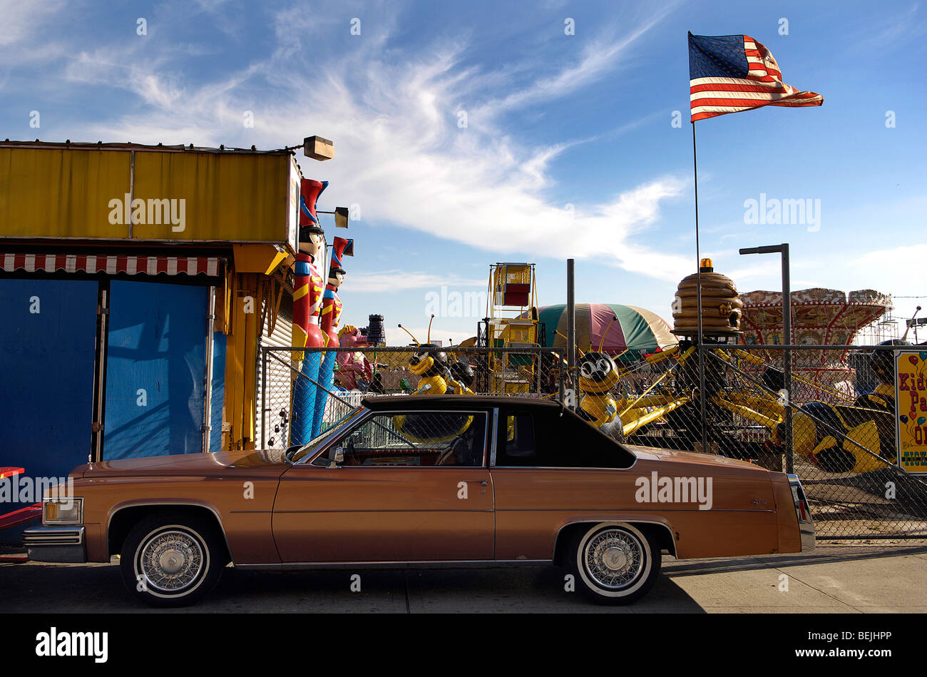 A vintage American car is parked beside a closed area of the Astroland fun park in Coney Island, New York City. Stock Photo