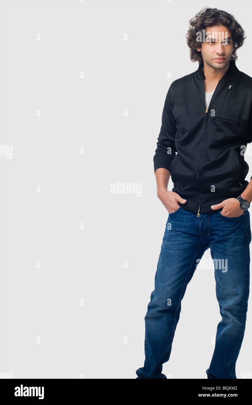 Young man standing with his hands in his pockets Stock Photo - Alamy