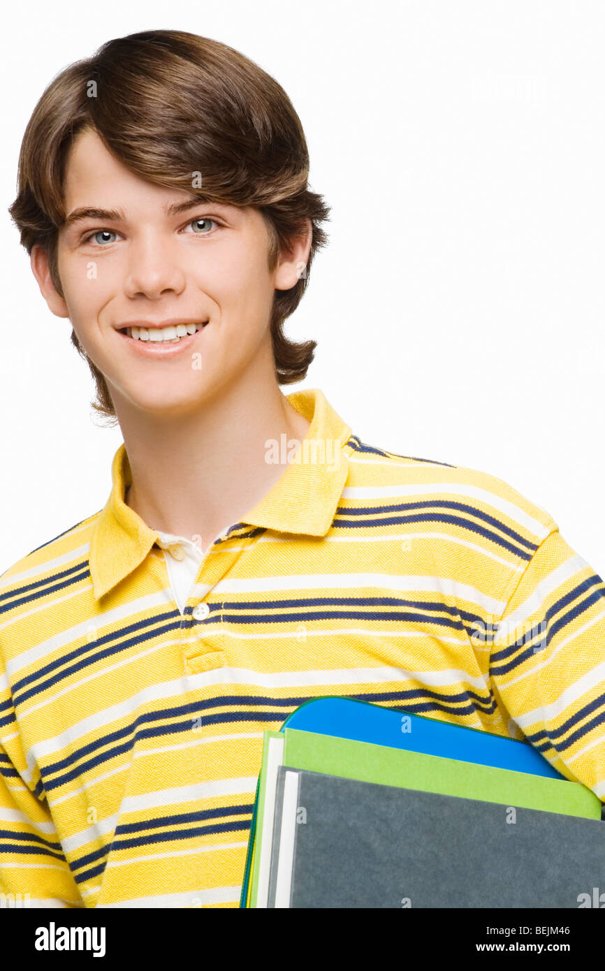 Portrait of a teenage boy holding books and ring binders Stock Photo ...