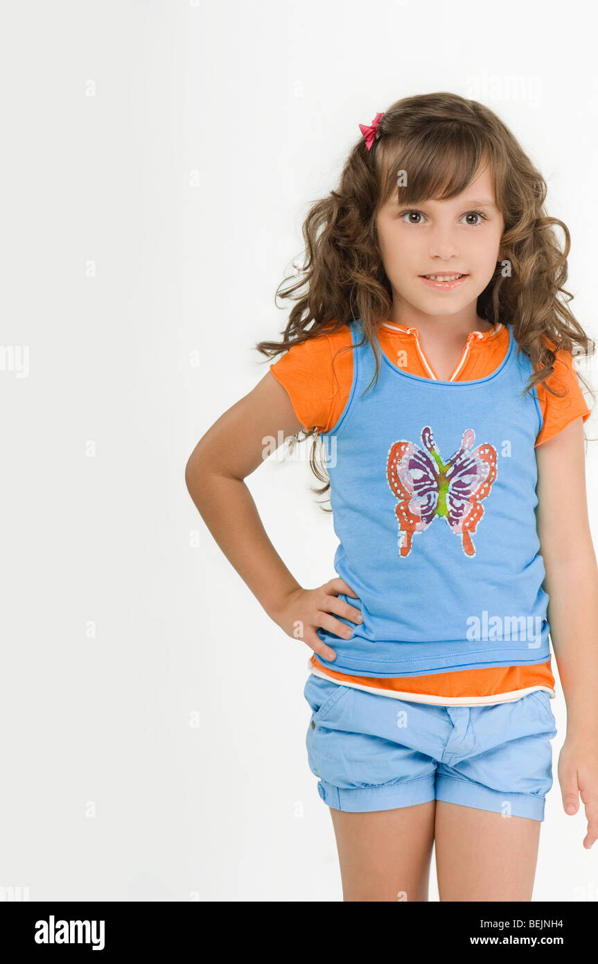 Portrait of a girl standing with her hand on her hip and smiling Stock ...