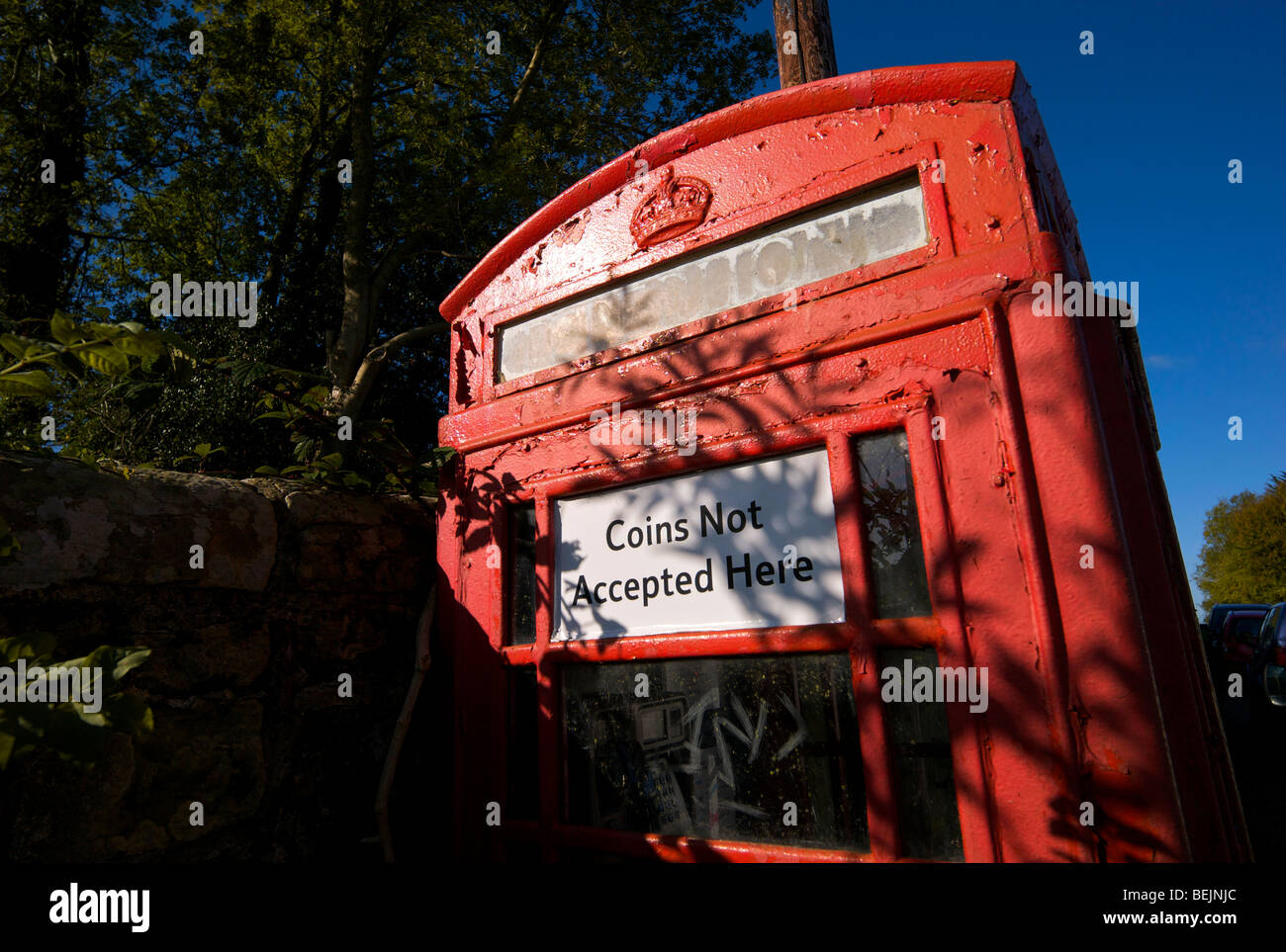 An old style telephone kiosk that no longer accepts coins as payment