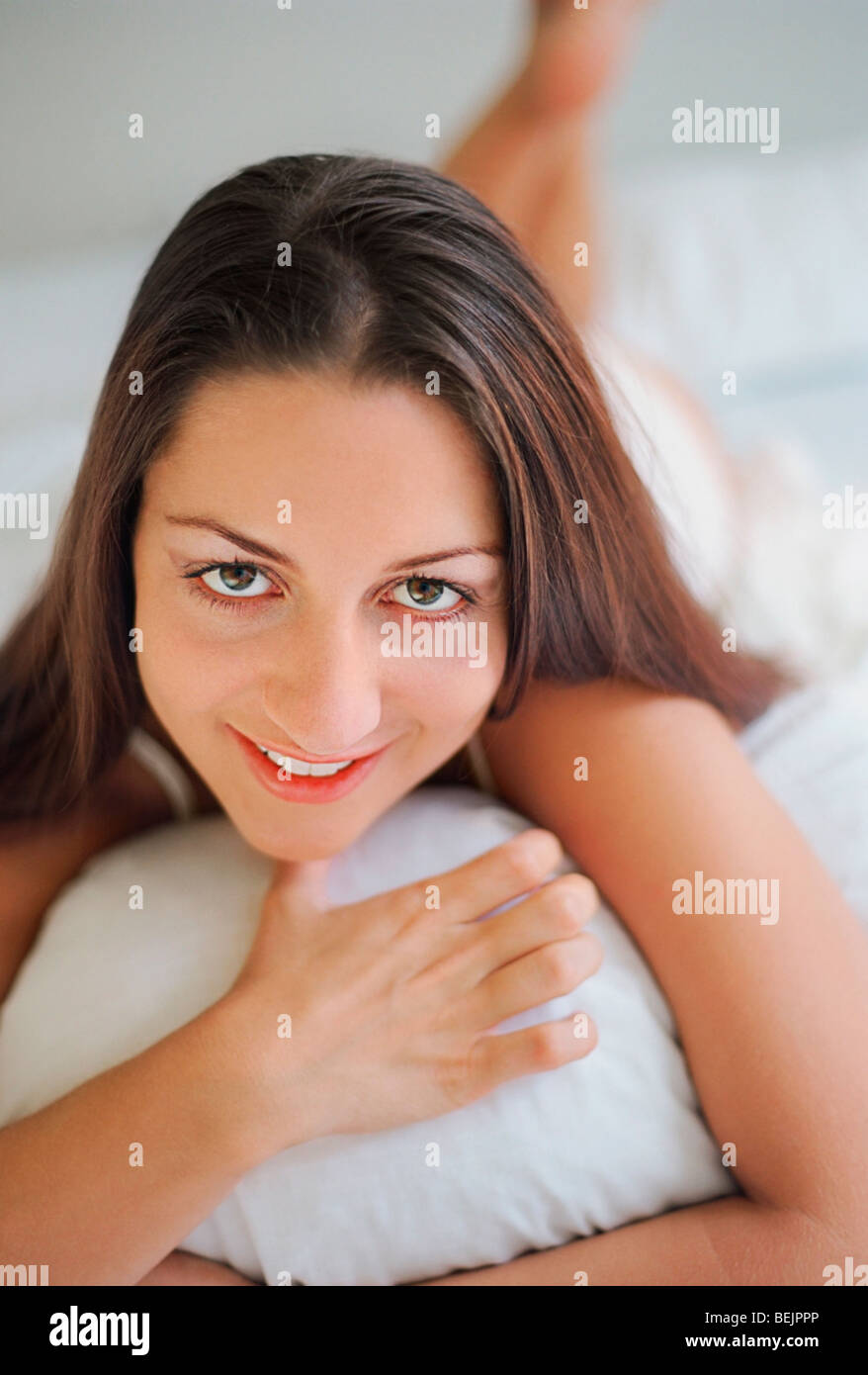 Portrait of a mid adult woman lying on the bed and smiling Stock Photo ...