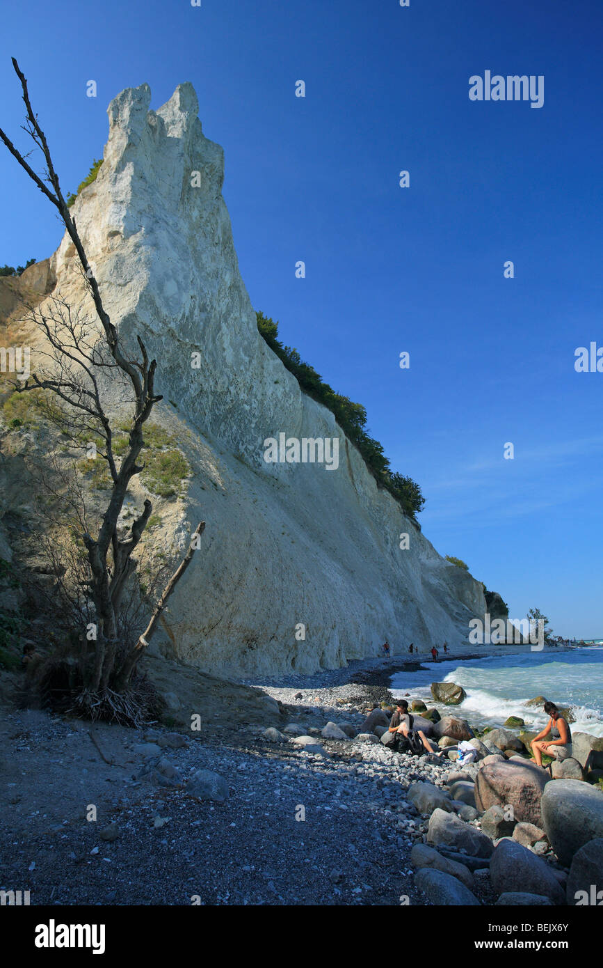 People walking on pebble beach along chalk cliff on the Island Mon