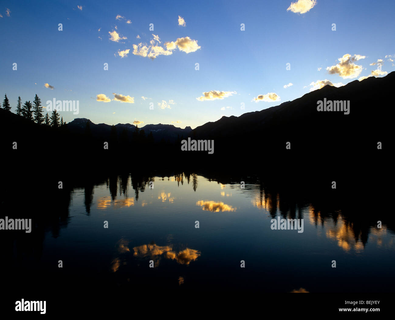 Sunset in the Rockies. Bow River. Trees silhouetted. Reflections. Banff National Park. BANFF. ALBERTA. CANADA. Stock Photo