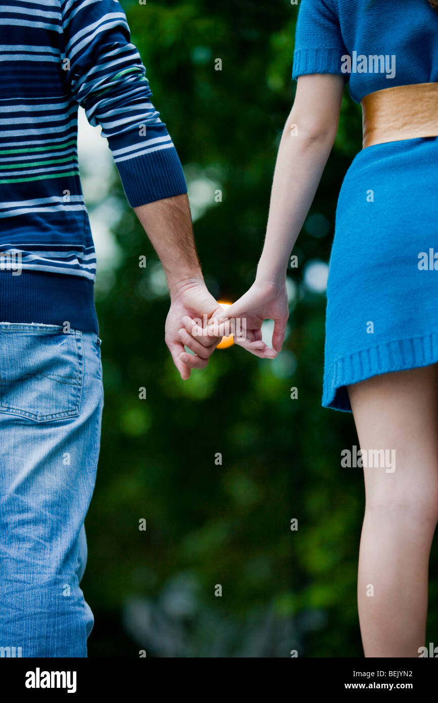 Unrecognizable couple holding hands walking hi-res stock photography ...