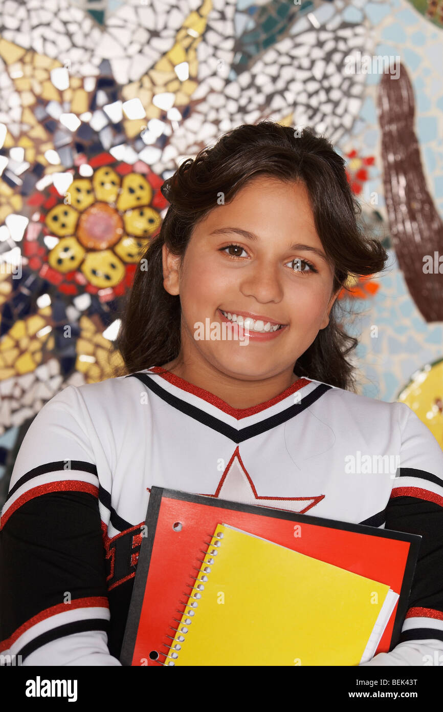 Portrait of a girl holding books and smiling Stock Photo - Alamy