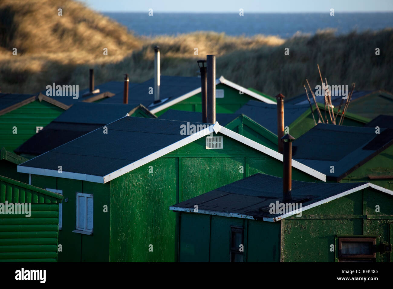 Several Tarpaulin roofed Fisherman's huts with chimneys; A hundred “South Gare Fishermen’s Association” cabins. Multiple sheds with doors & windows Stock Photo
