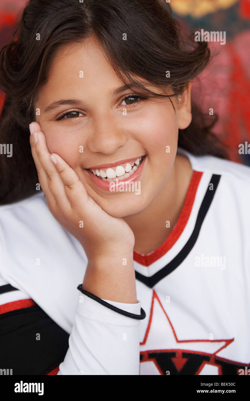 Portrait of a girl smiling with her hand on her chin Stock Photo - Alamy