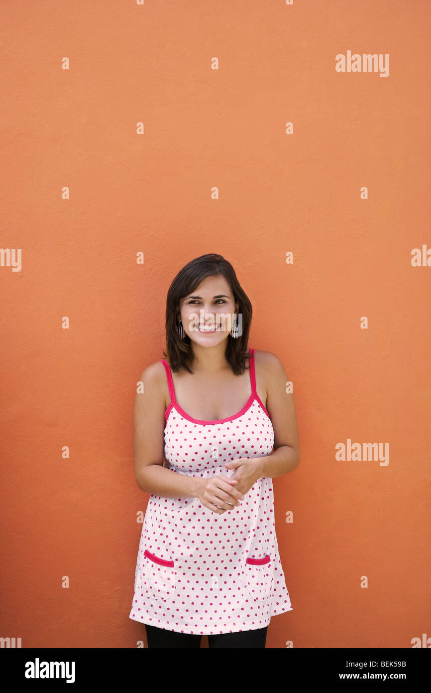 Young woman standing in front of a wall Stock Photo - Alamy