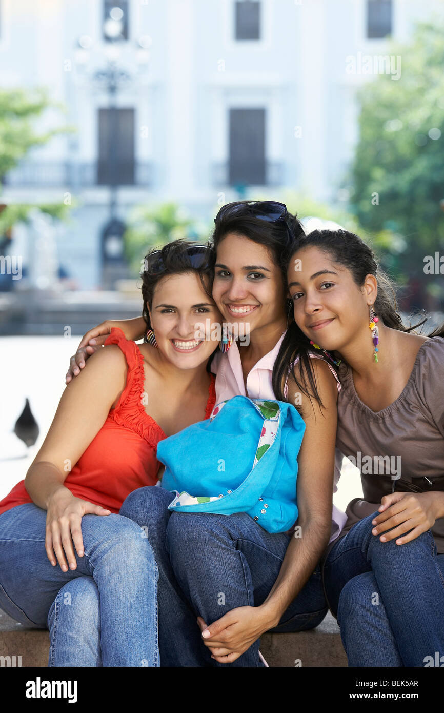 Portrait of three young women sitting and smiling Stock Photo - Alamy