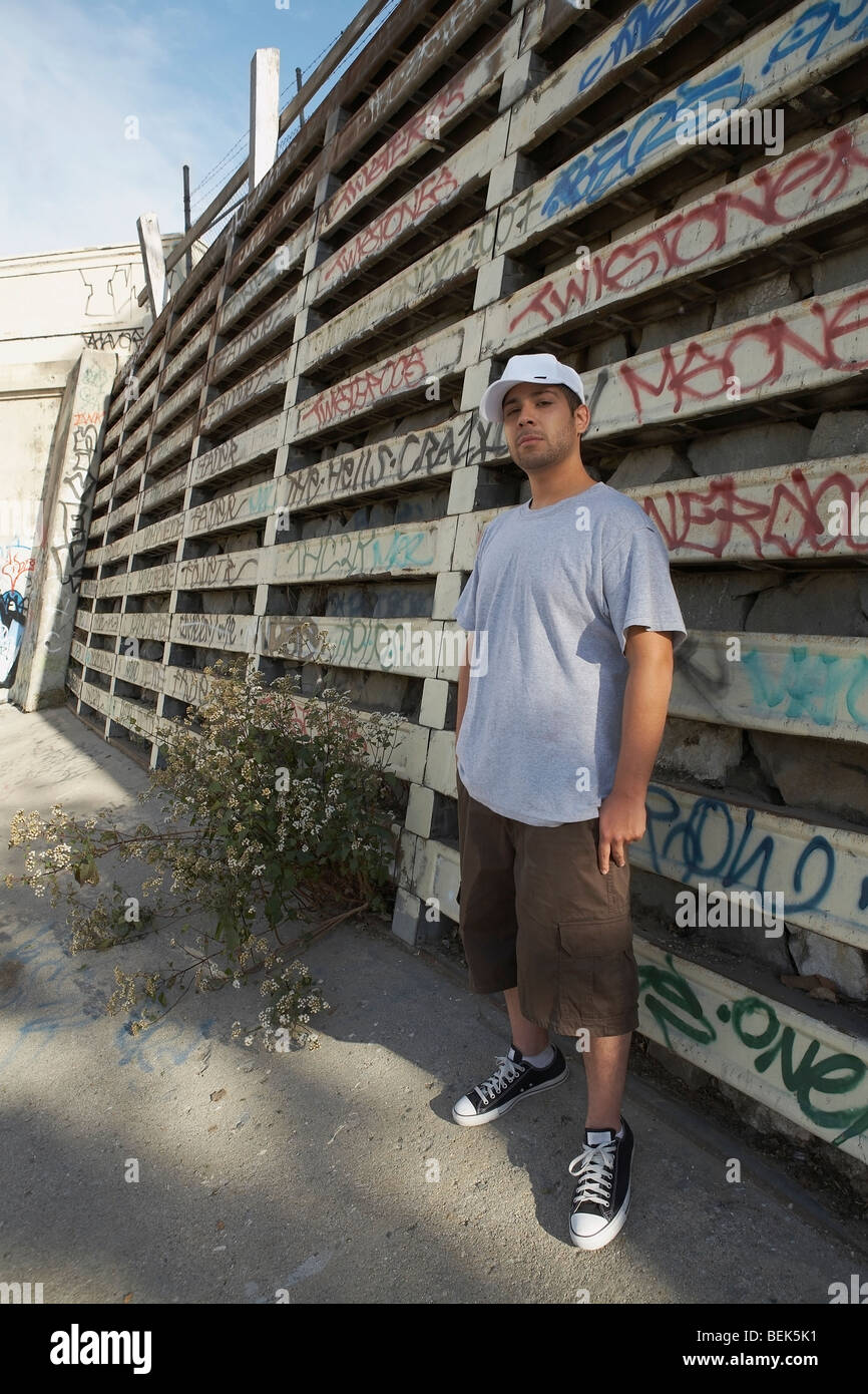 Young man standing in front of a wall Stock Photo - Alamy