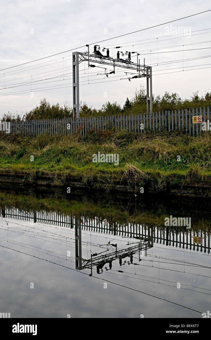 railway catenary overhead power cables near a mainline canal Stock Photo