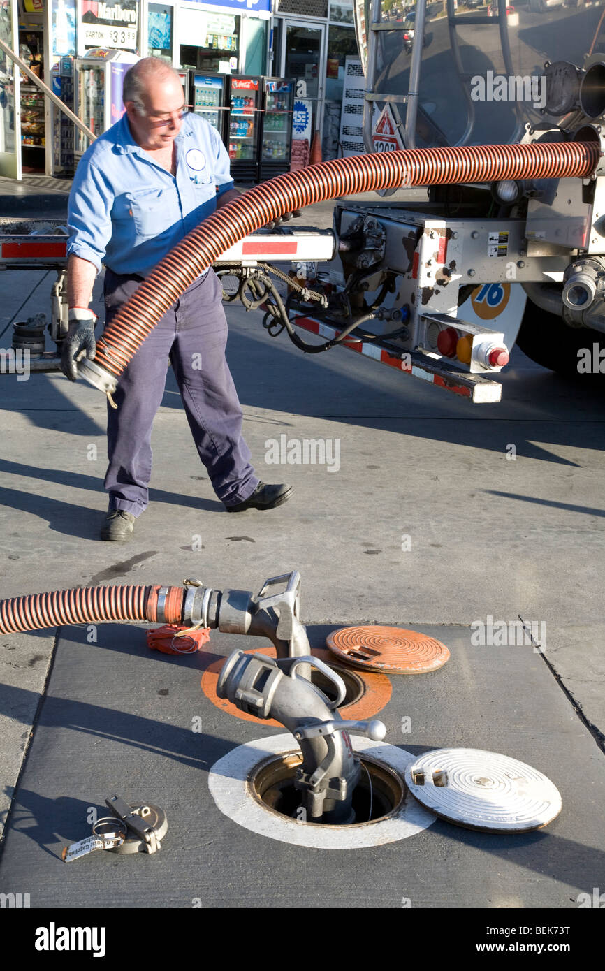 A gas truck driver storing a gas hose after delivering an underground tank. Mountain View, California, USA Stock Photo