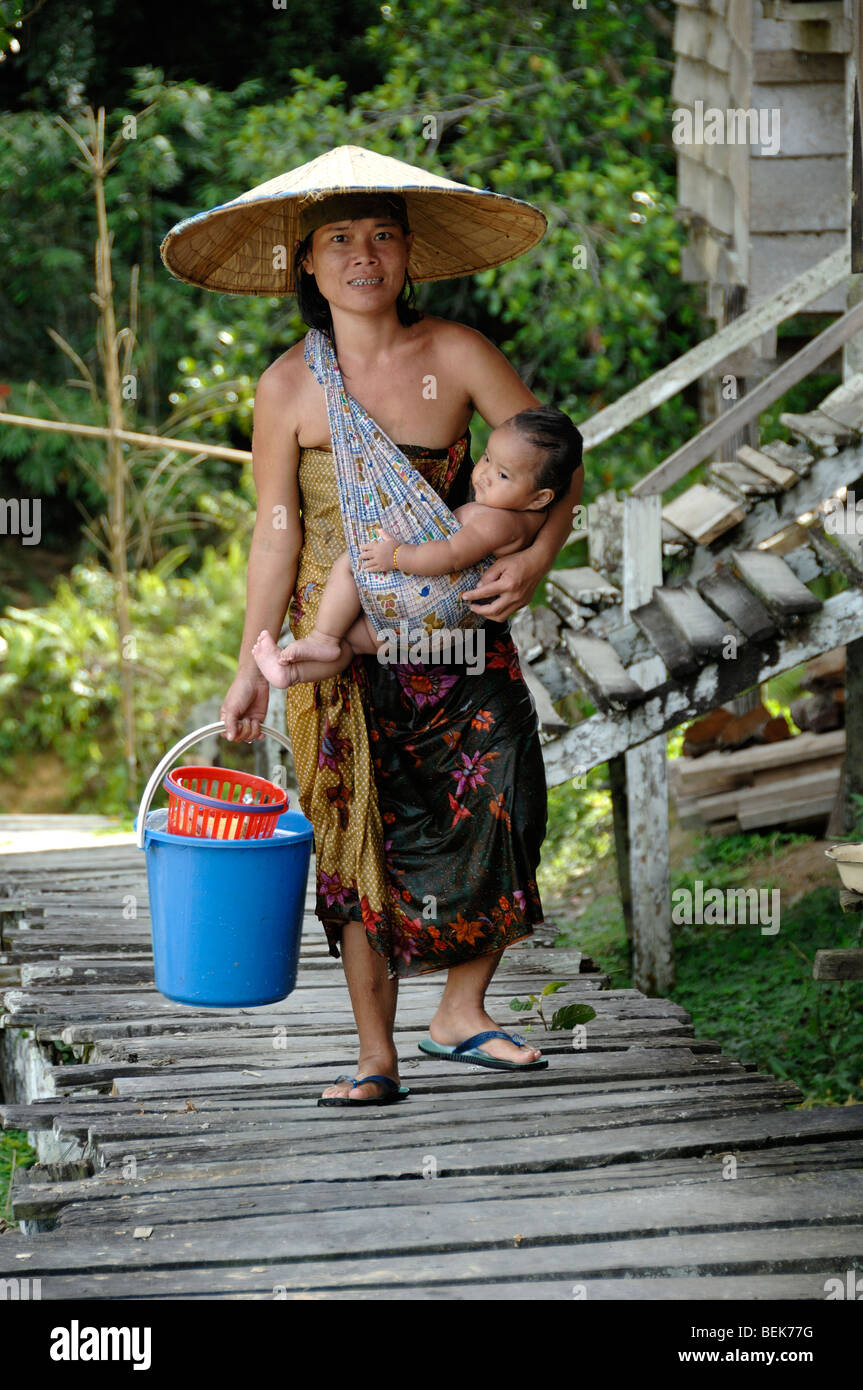 Iban Mother or Woman Carrying Child in Baby Sling at a Communal