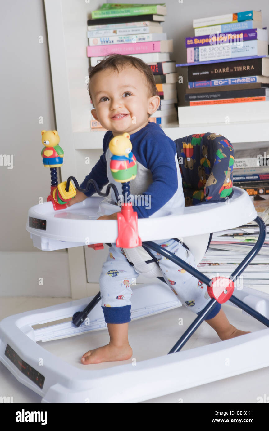 Baby boy playing in a walker Stock Photo Alamy