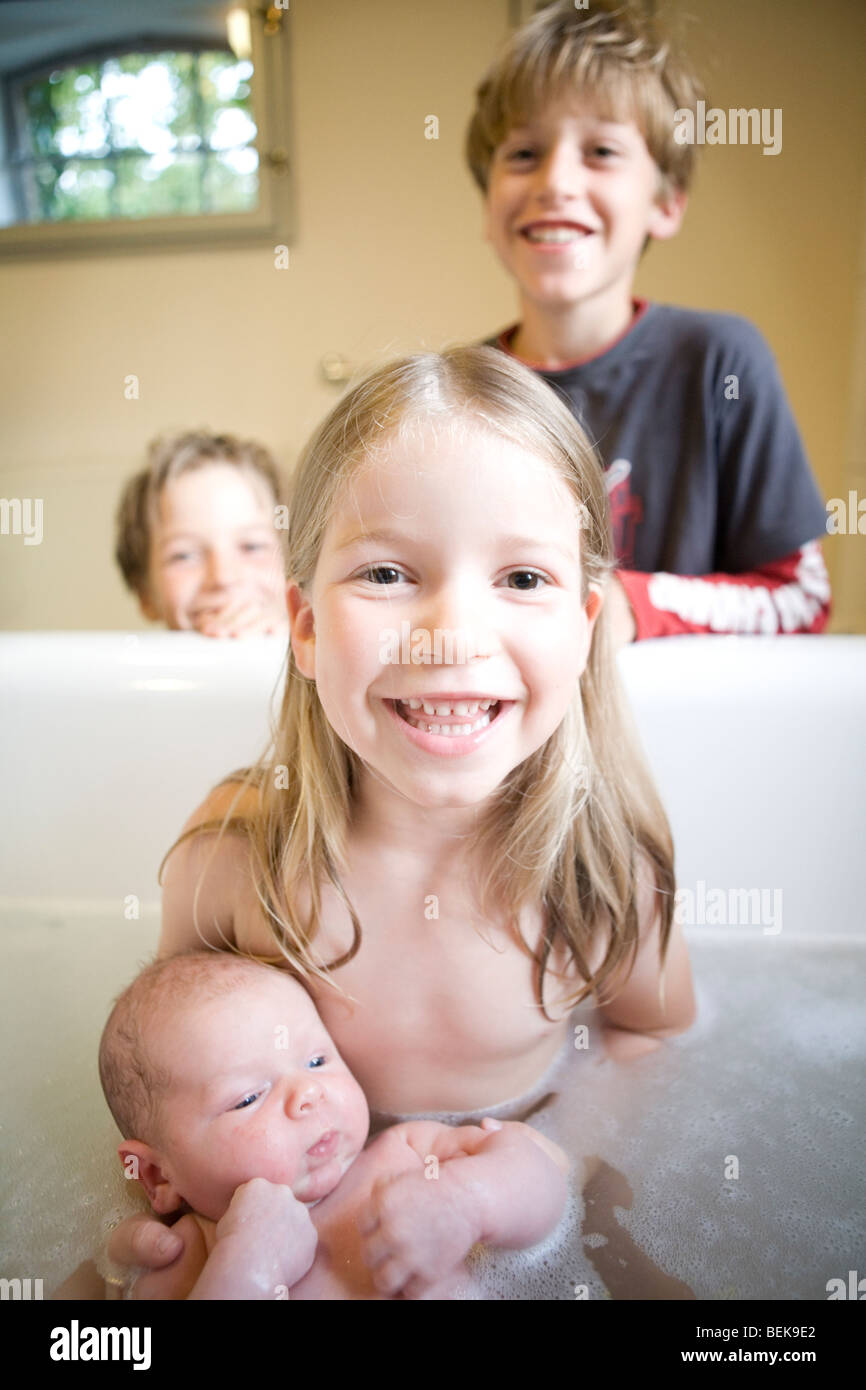 Brothers and sister at bath time with the new baby Stock Photo - Alamy
