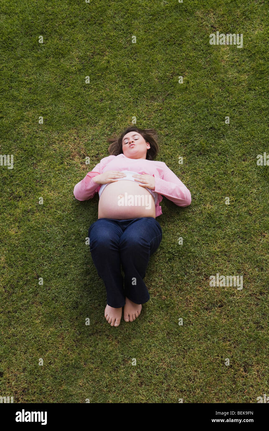 High angle view of a pregnant woman lying in a lawn Stock Photo