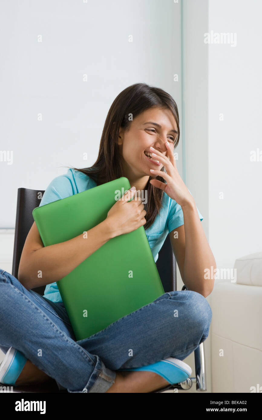 Teenage girl smiling and holding a laptop Stock Photo - Alamy