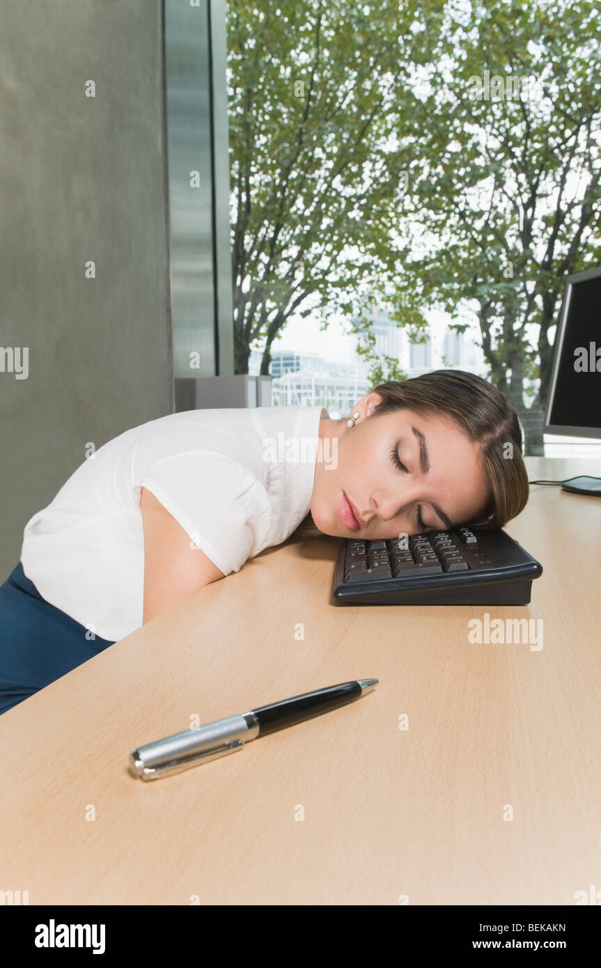 Businesswoman sleeping on a desk in an office Stock Photo - Alamy