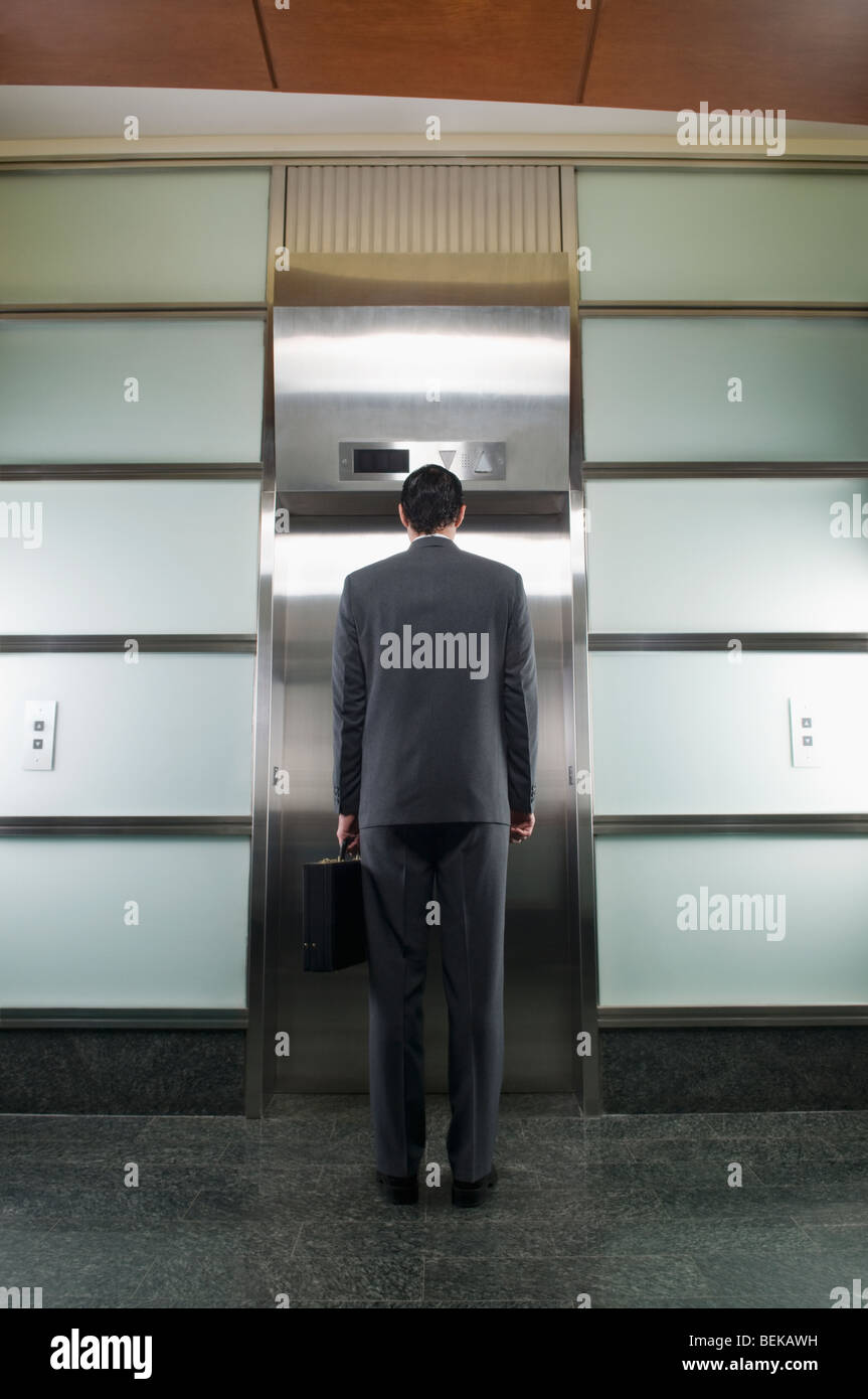 Businessman waiting for elevator Stock Photo