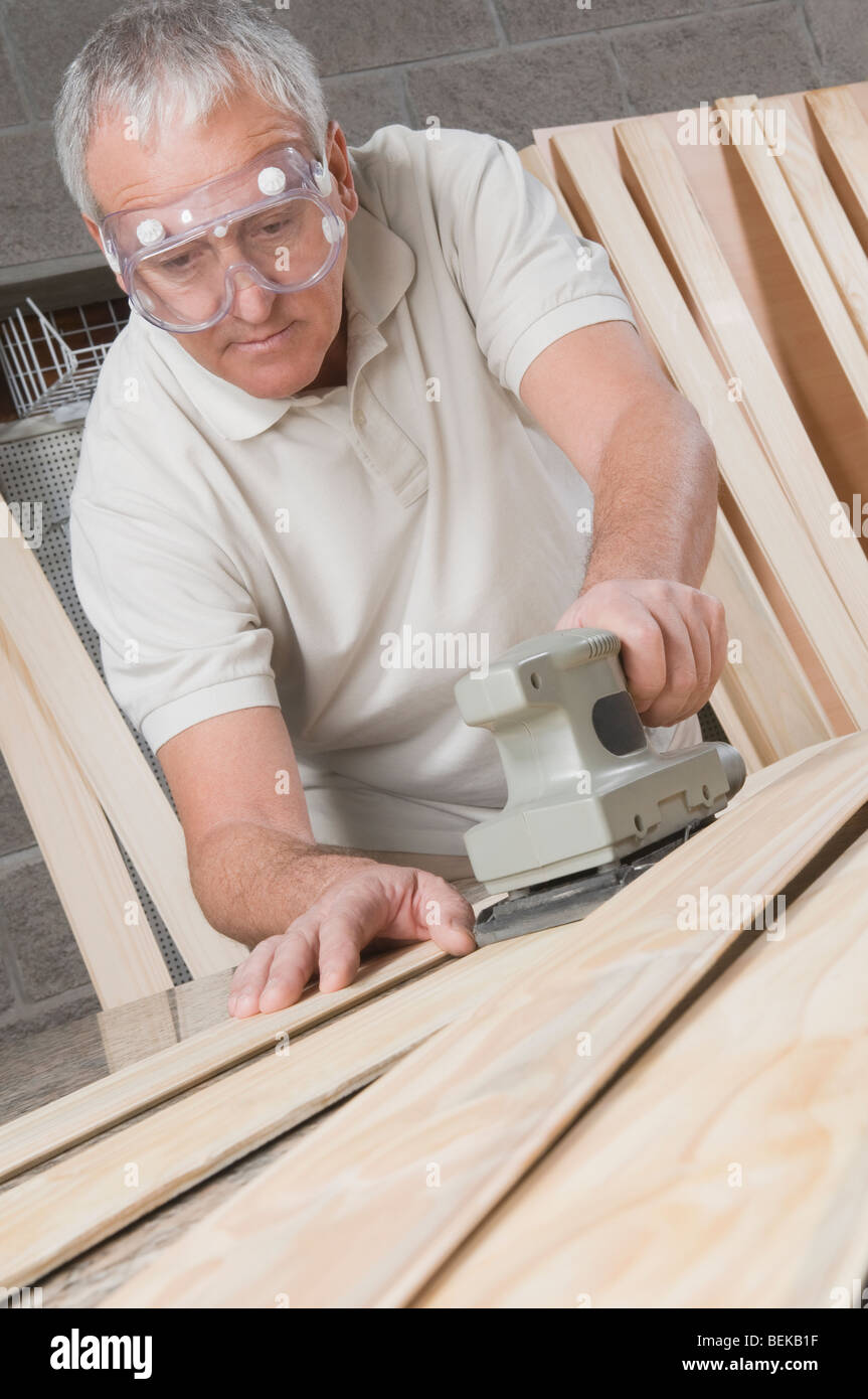 Carpenter planing a wooden plank Stock Photo