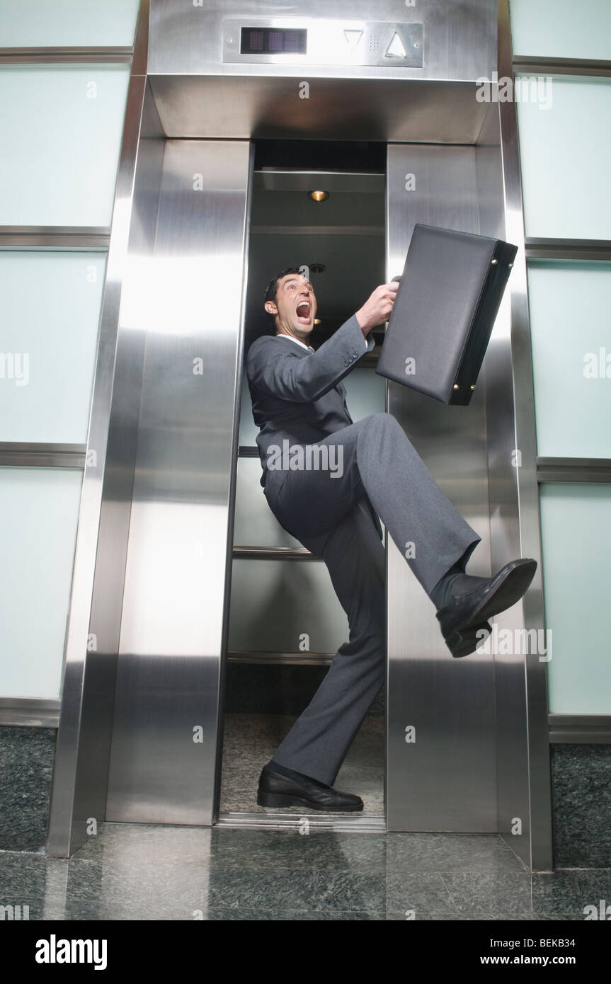 Businessman wedged between elevator doors Stock Photo