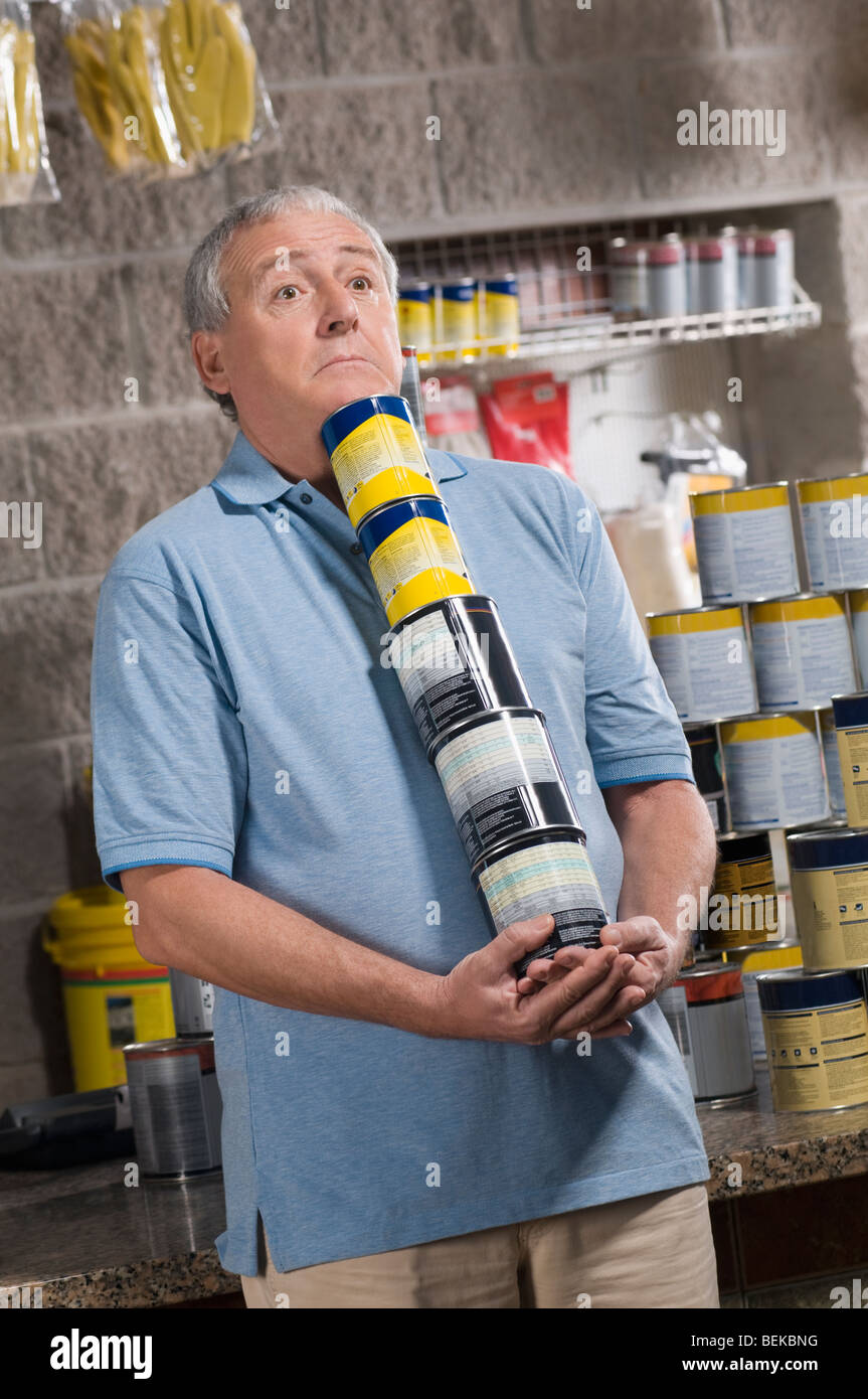 Man holding paint cans in a hardware store Stock Photo
