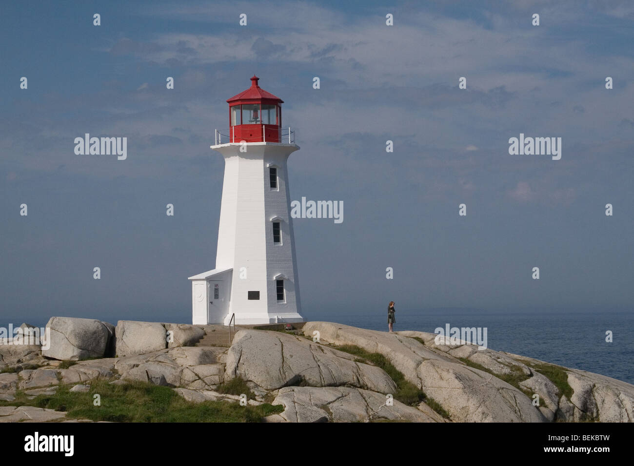 Lone visitor watches waves crash against the rocks at the Peggy's Cove