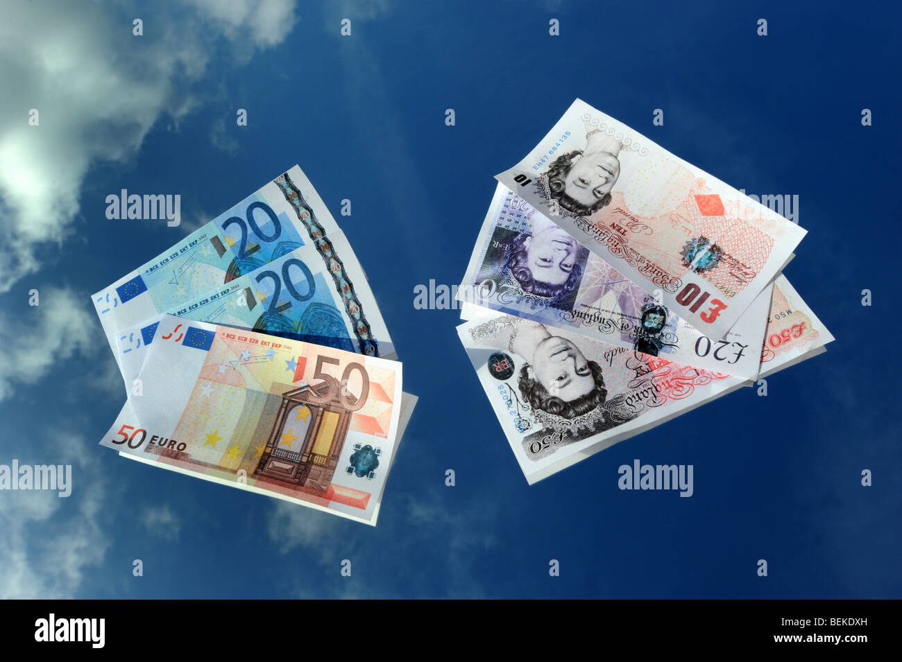 Euro and Pound Sterling currency notes reflected against a blue sky Stock Photo