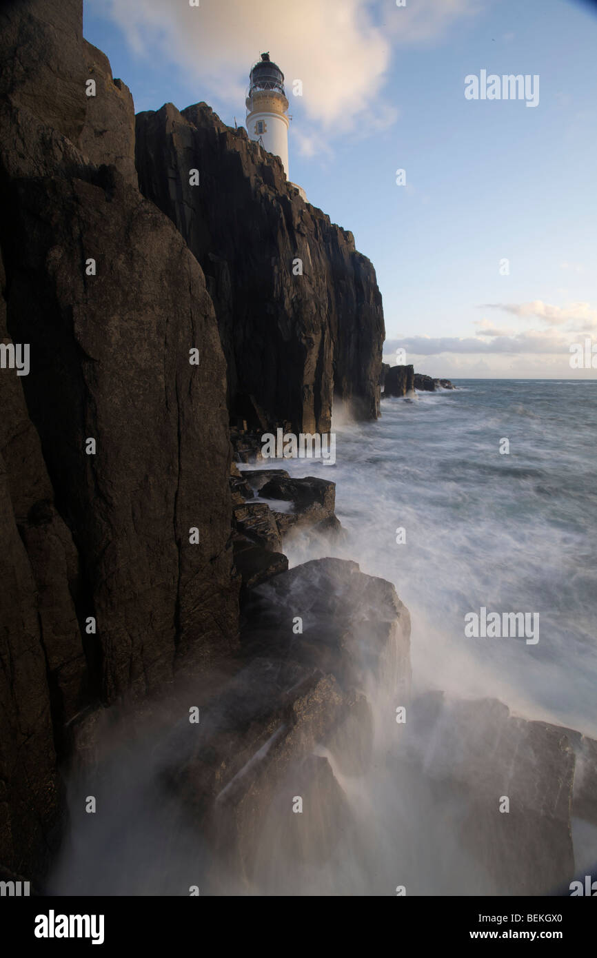 Neist Point lighthouse with misty seas and rocks in the foreground, Isle of Skye, Scotland Stock Photo