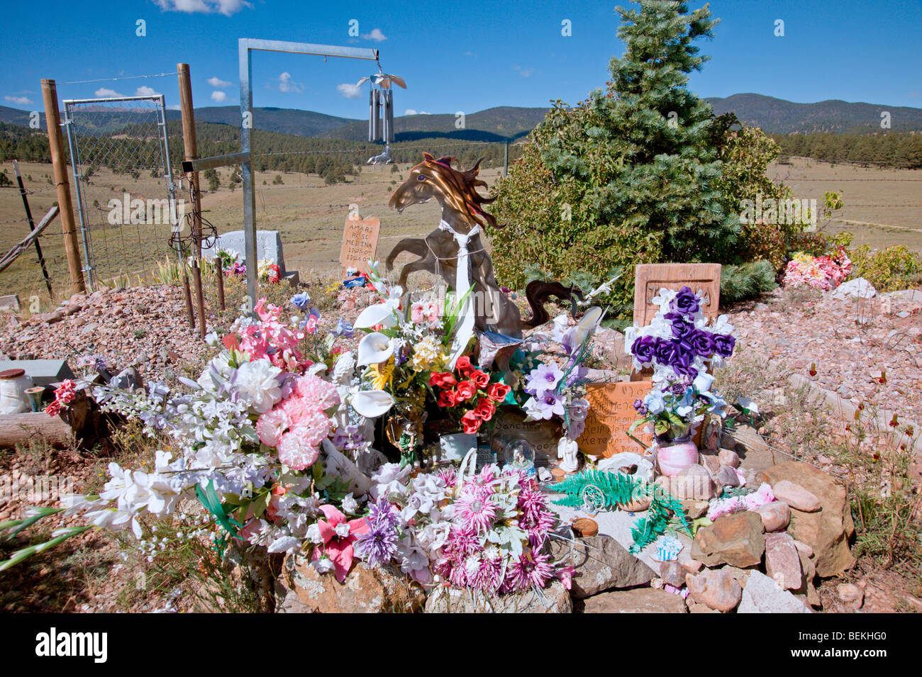A colorful spray of flowers and a collection of unusual remembrances mark this resting place in the Elizabethtown cemetery - NM. Stock Photo