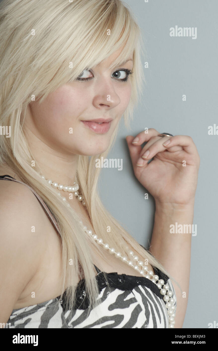 Young attractive and fashionable woman wearing striking clothing and long blonde hair. Stock Photo
