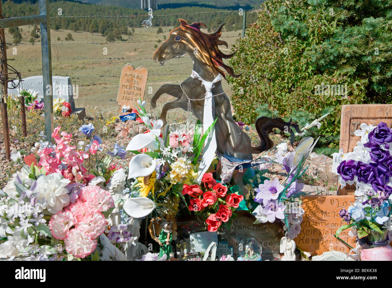A colorful spray of flowers and a collection of unusual remembrances mark this resting place in the Elizabethtown cemetery - NM. Stock Photo