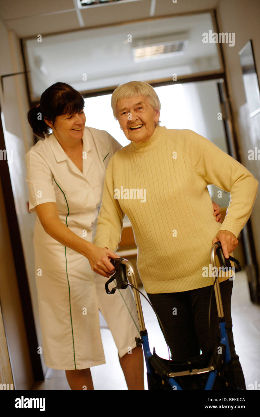 Elderly lady with Female therapist in hospice corridor Stock Photo