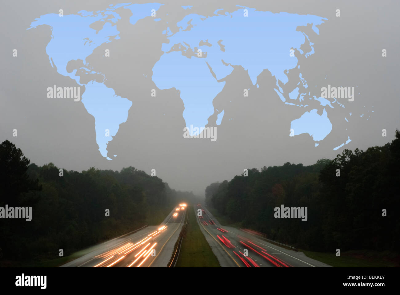 blue outline of a world map above a highway with cars on a grey, rainy evening Stock Photo