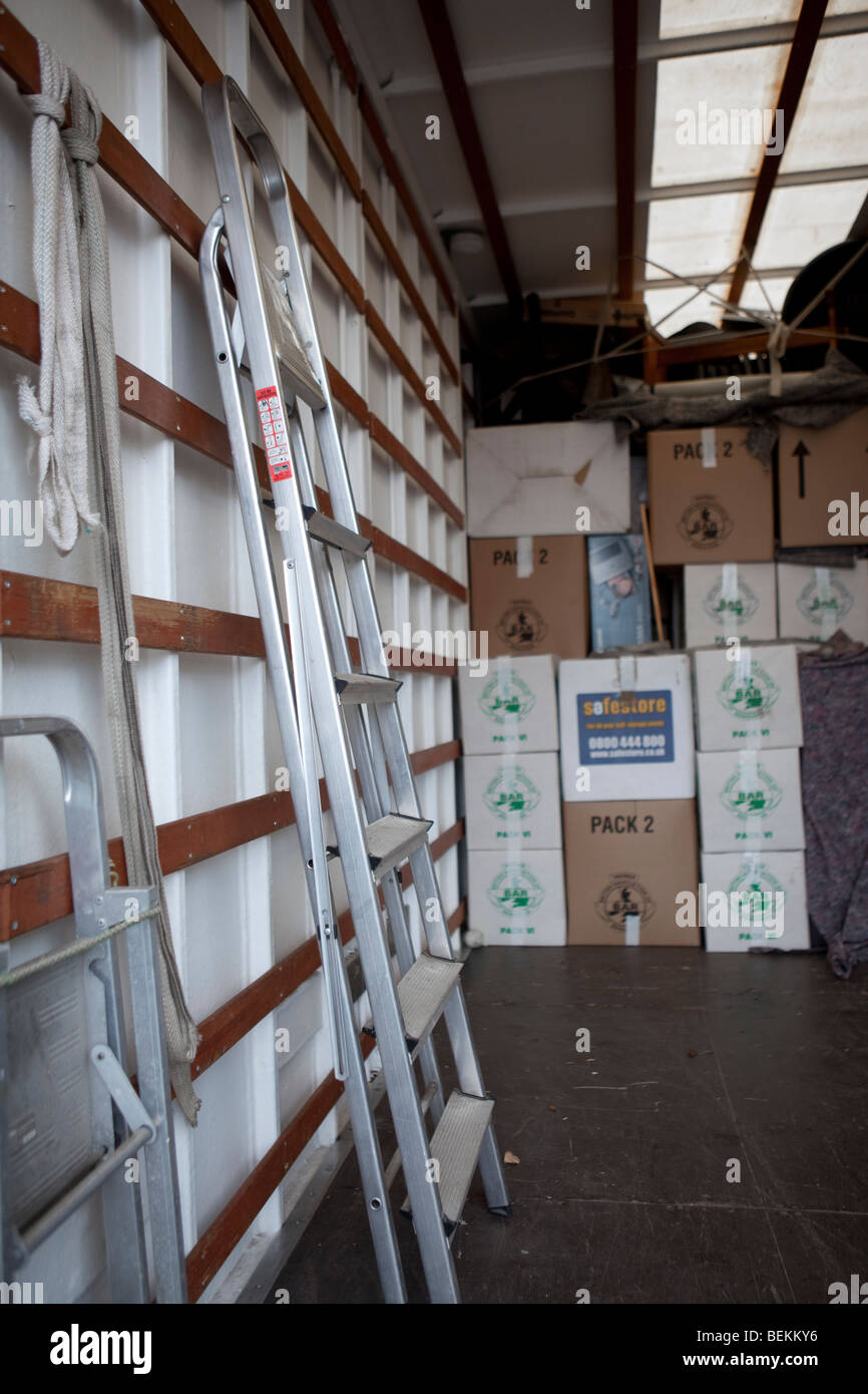 Blankets, step ladders and cartons / boxes inside the back of a removal truck, in the process of moving house. Stock Photo
