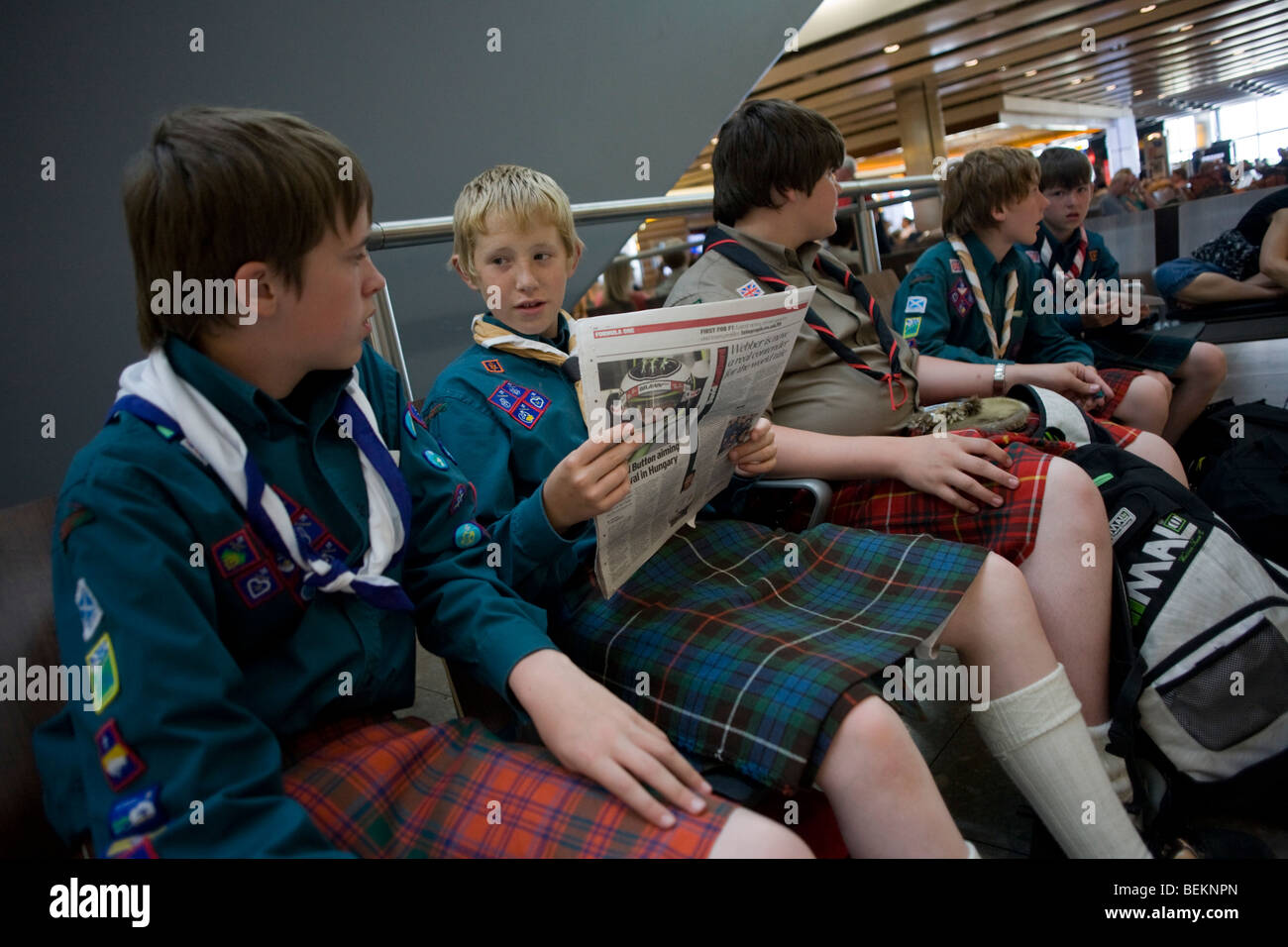Boys from a Scottish scout group sit and in the departures concourse of Heathrow Airport's Terminal 5. Stock Photo