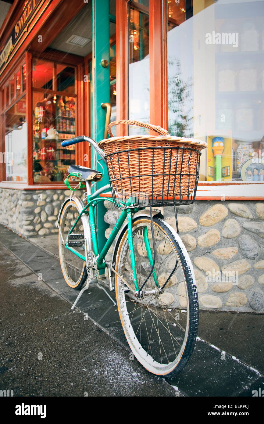 Cruiser bicycle with basket parked outside a storefront, Banff, Alberta, Canada. Stock Photo
